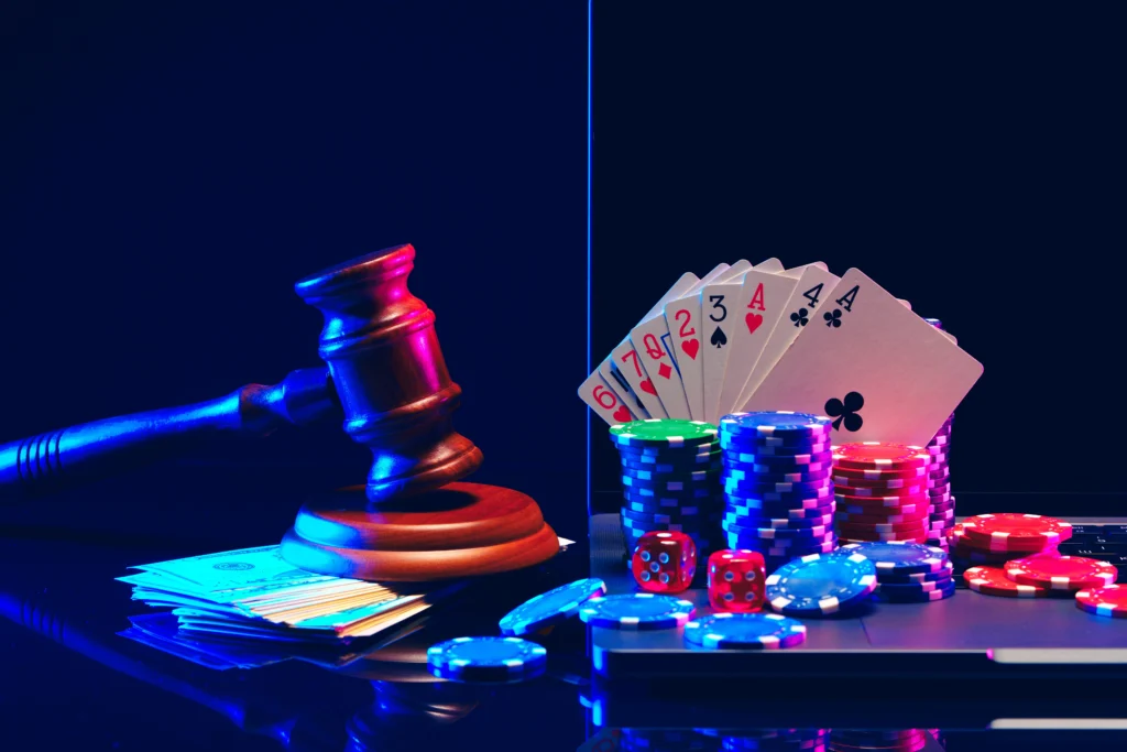 A judge's gavel, playing cards, poker chips, and dice are on a reflective surface against a dark background, symbolizing hotel and casino security negligence.