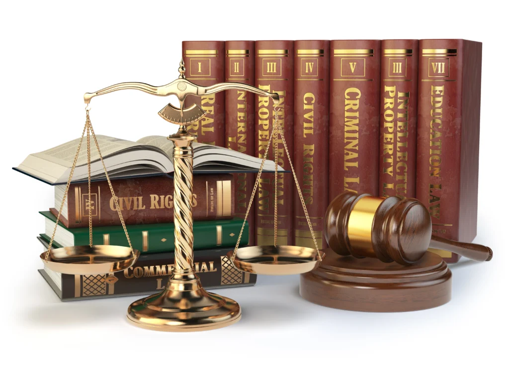 A set of legal books arranged upright with titles like Civil Rights and Criminal Law. A golden balance scale and a wooden gavel rest in front.